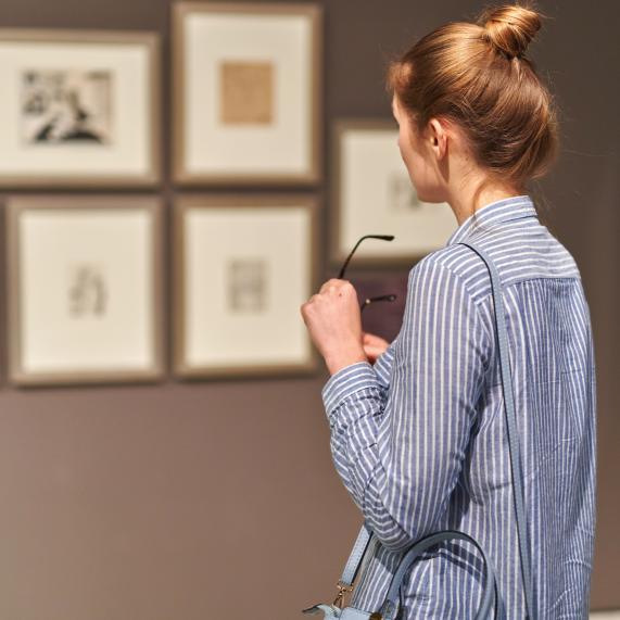 Dona veient obres d'art en un museu