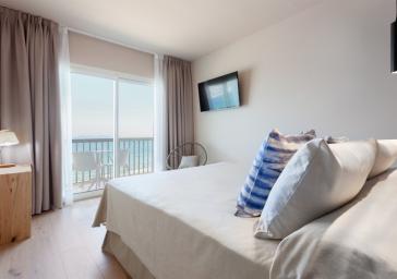 Habitación con cama doble con vistas al mar en hotel de Roses